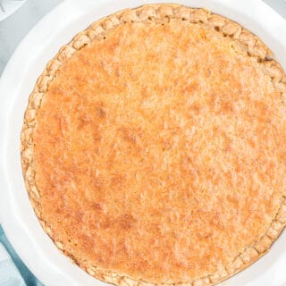 A homemade toasted coconut pie in a white pie plate.