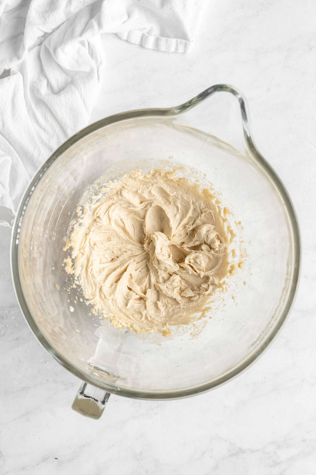 Custard being made in a stand mixer bowl on white countertop