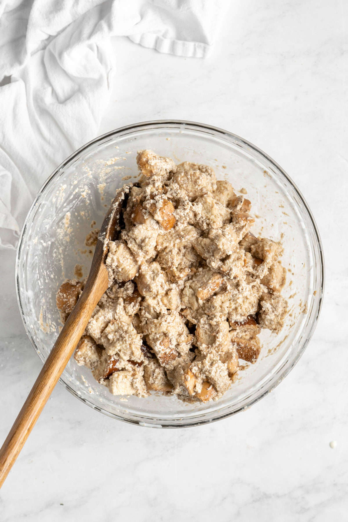 Liquids added to bread pudding mixture in glass bowl.