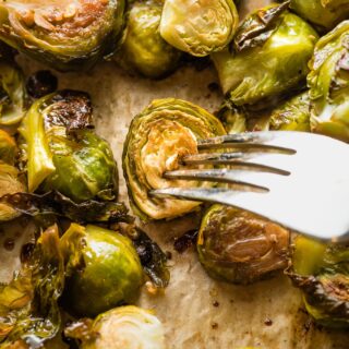 Close up of roasted brussels sprouts with a fork poking into one