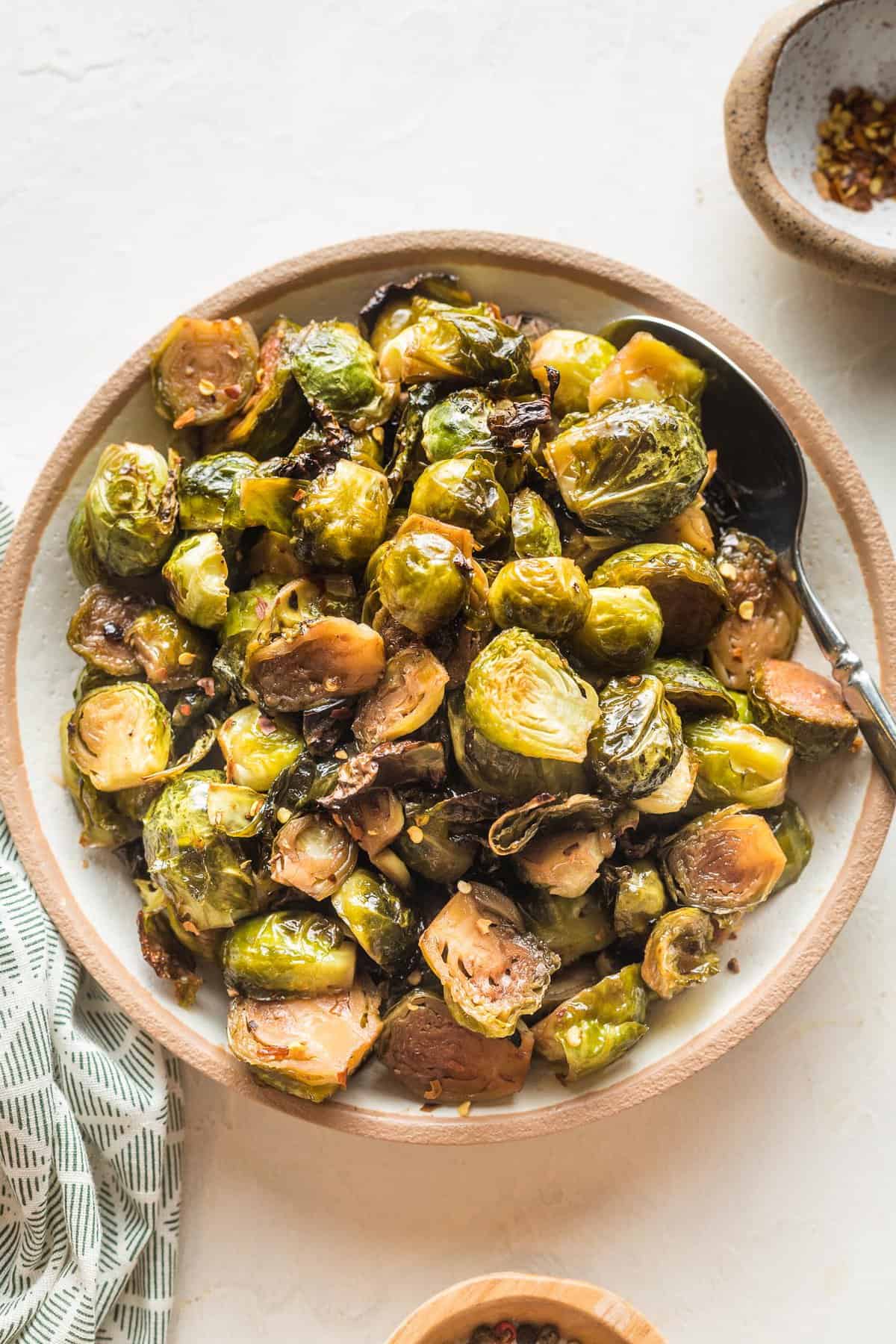 overhead of a bowl full of roasted brussels sprouts and a spoon