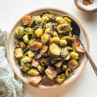overhead of a bowl full of roasted brussels sprouts and a spoon