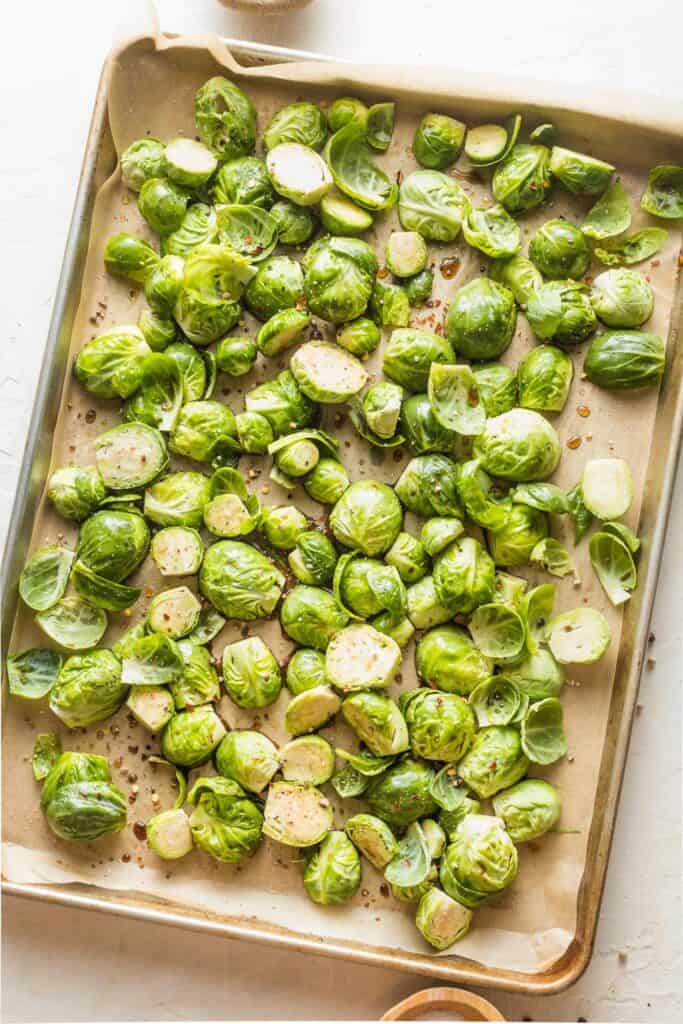 seasoned raw brussels sprouts on a baking sheet