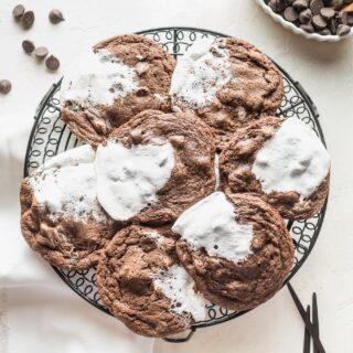 Hot chocolate cookies with marshmallow cooling on a wire rack.