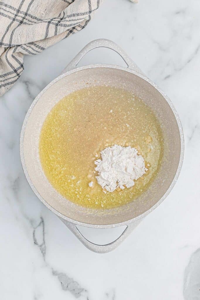 Butter and flour cooking in a pot on white countertop