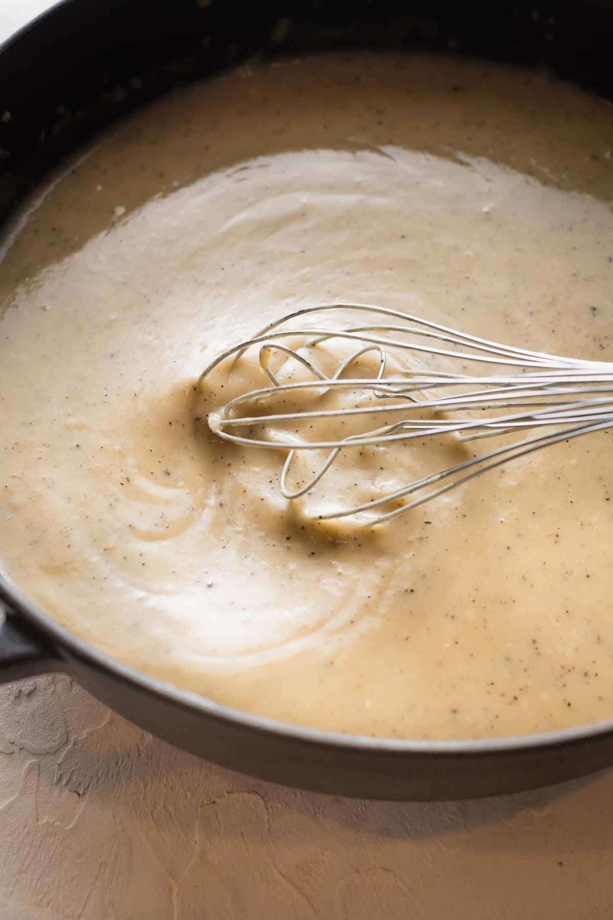 whisking gravy in a sauce pan