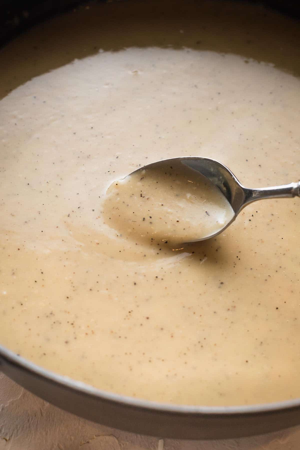 gravy sticking to the back of a spoon in a sauce pan