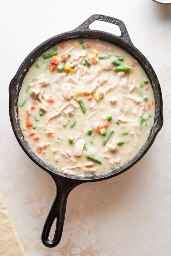 Turkey pot pie filling in a cast iron skillet.
