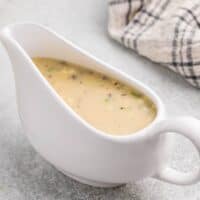 A white gravy boat filled with homemade turkey giblet gravy.