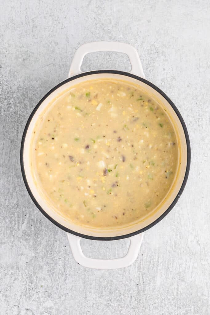 Top view of a white cast iron stockpot filled with gravy made with turkey giblets