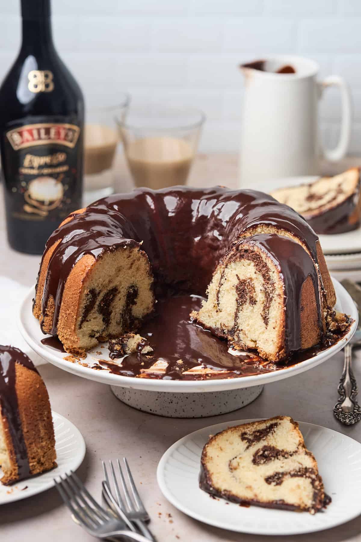 A brownie bundt cake on a platter with a slice taken out.