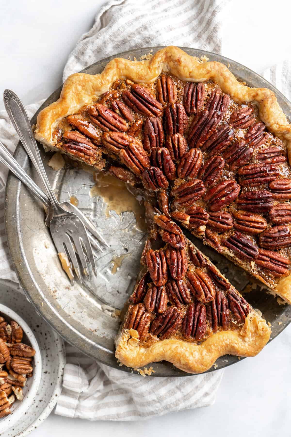 A cut into easy pecan pie recipe with forks on it before serving up