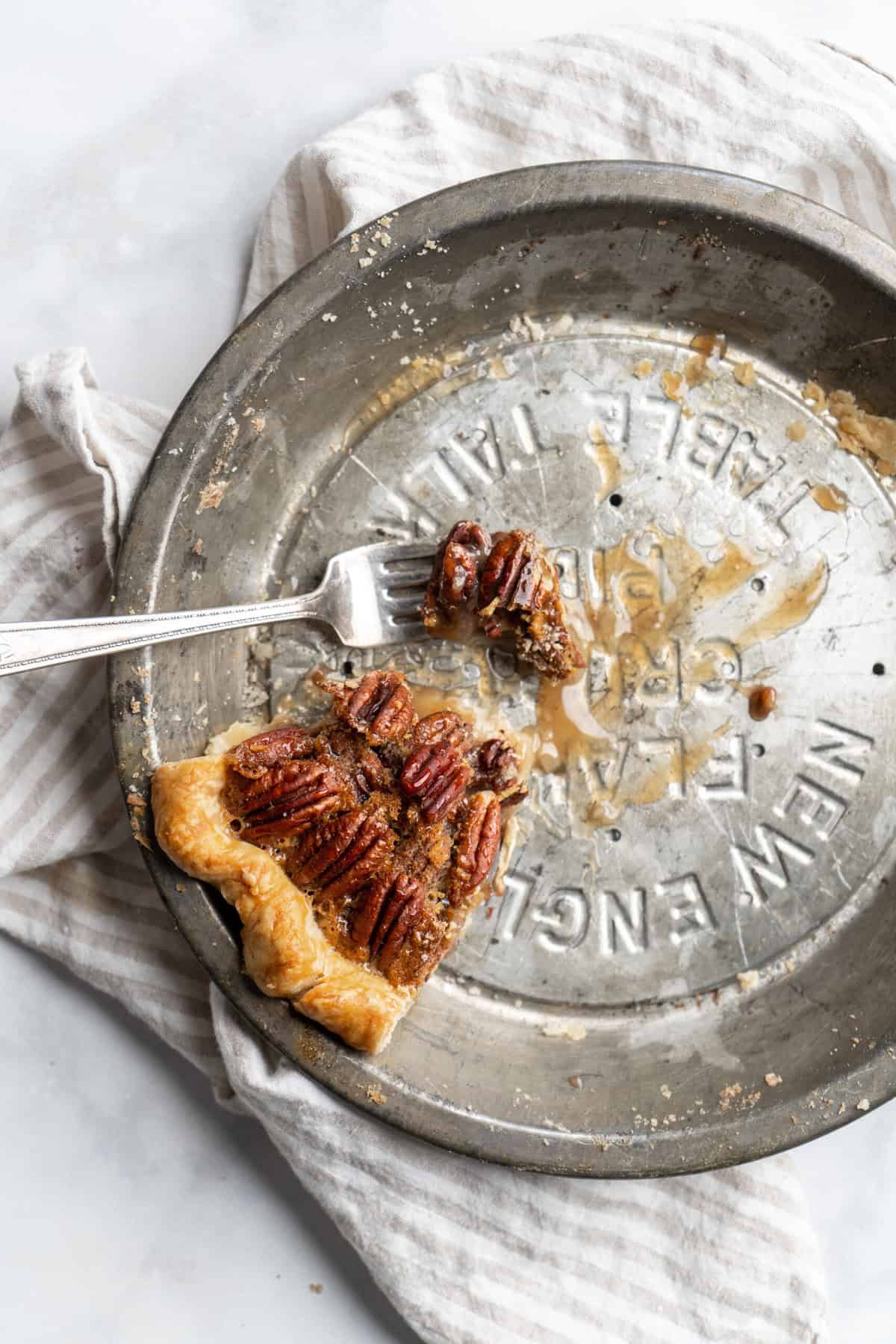 A slice of Southern pecan pie recipe in a tin left behind being eten