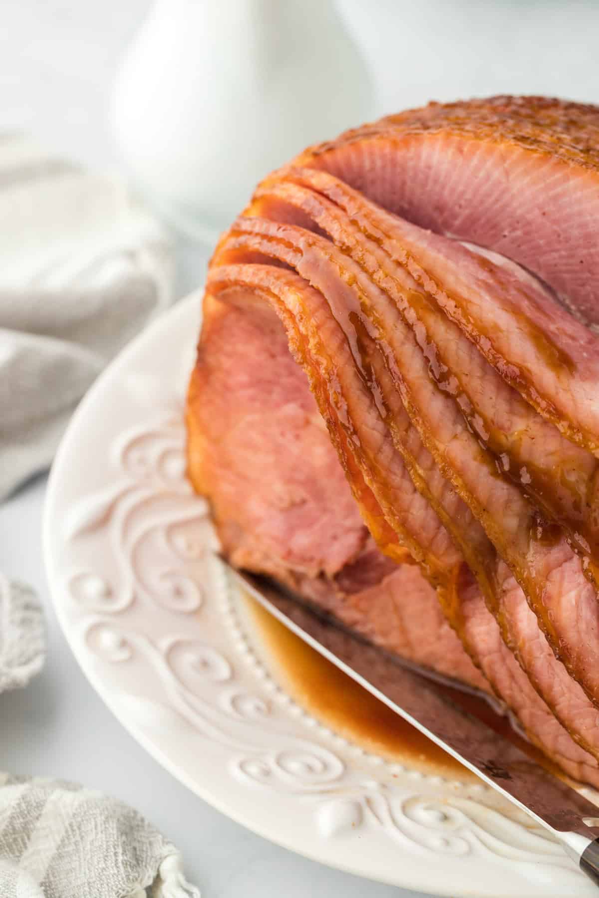 Sliced spiral honey ham on white platter ready to serve