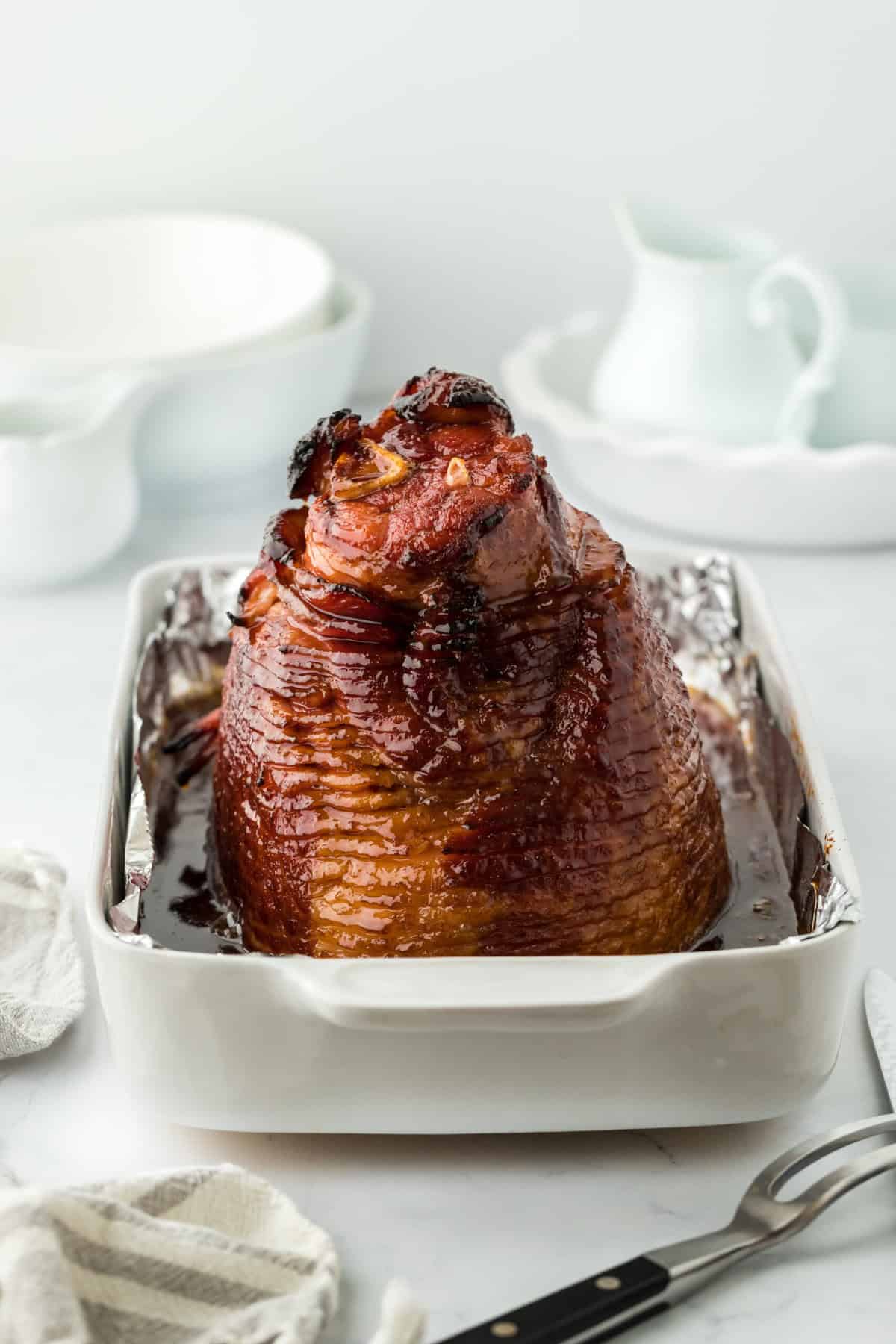 Perfectly roasted ham on white baking sheet in white background