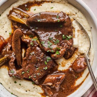 Braised beef short ribs over a bowl of corn grits.