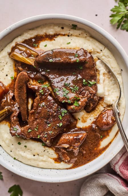 Braised beef short ribs over a bowl of corn grits.