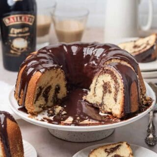 brownie swirl cake on a platter with a slice taken out