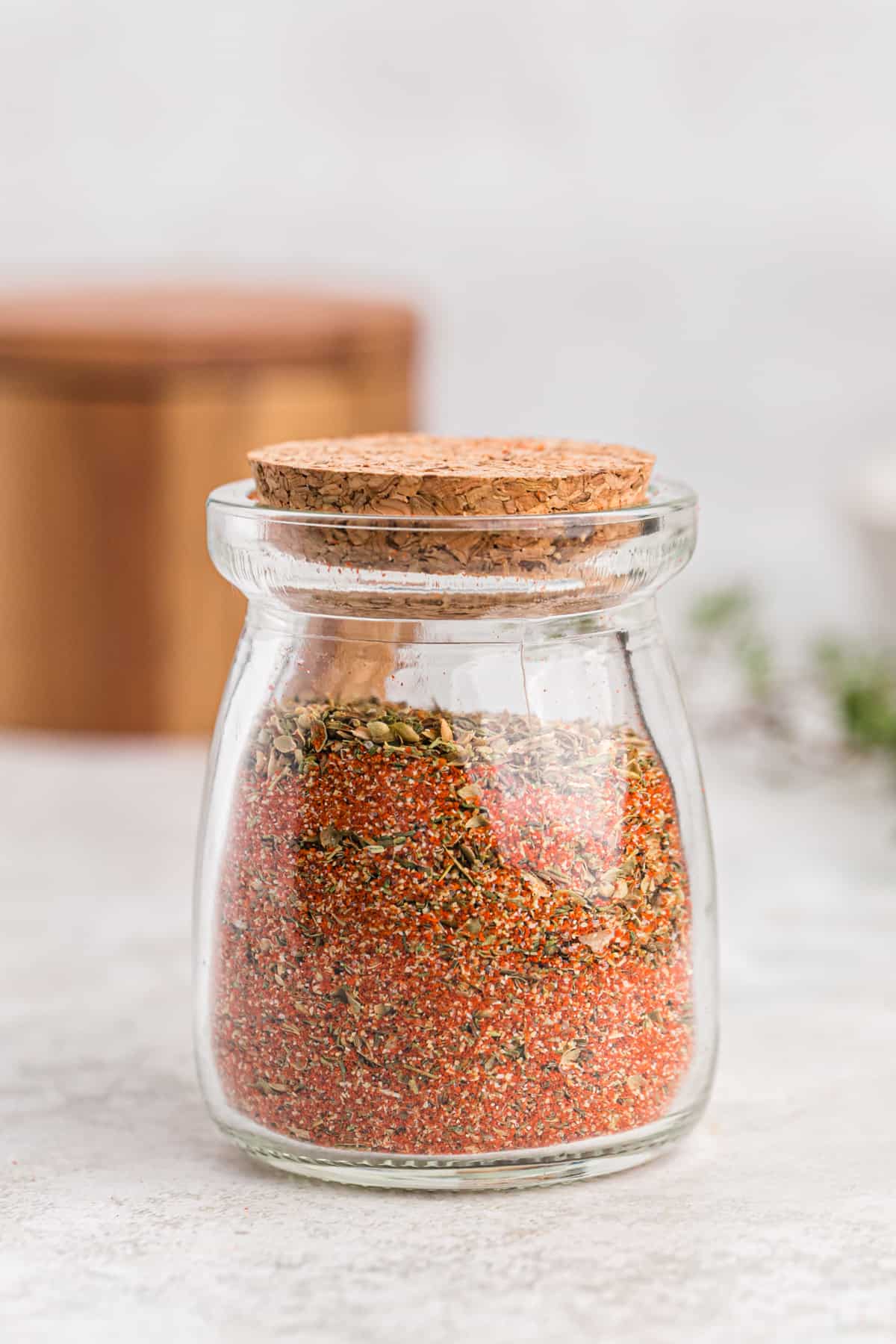 A small jar filled with blackened seasoning and topped with a cork.