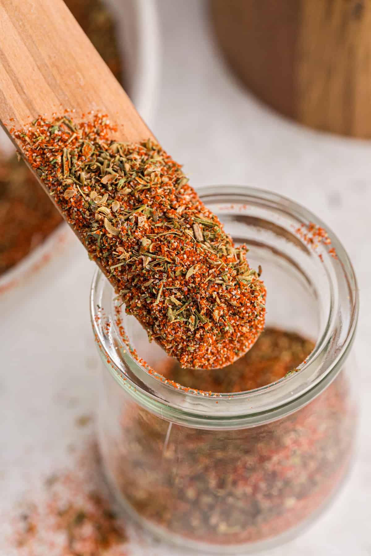 A wooden stick dipped into a jar of blackened seasoning.