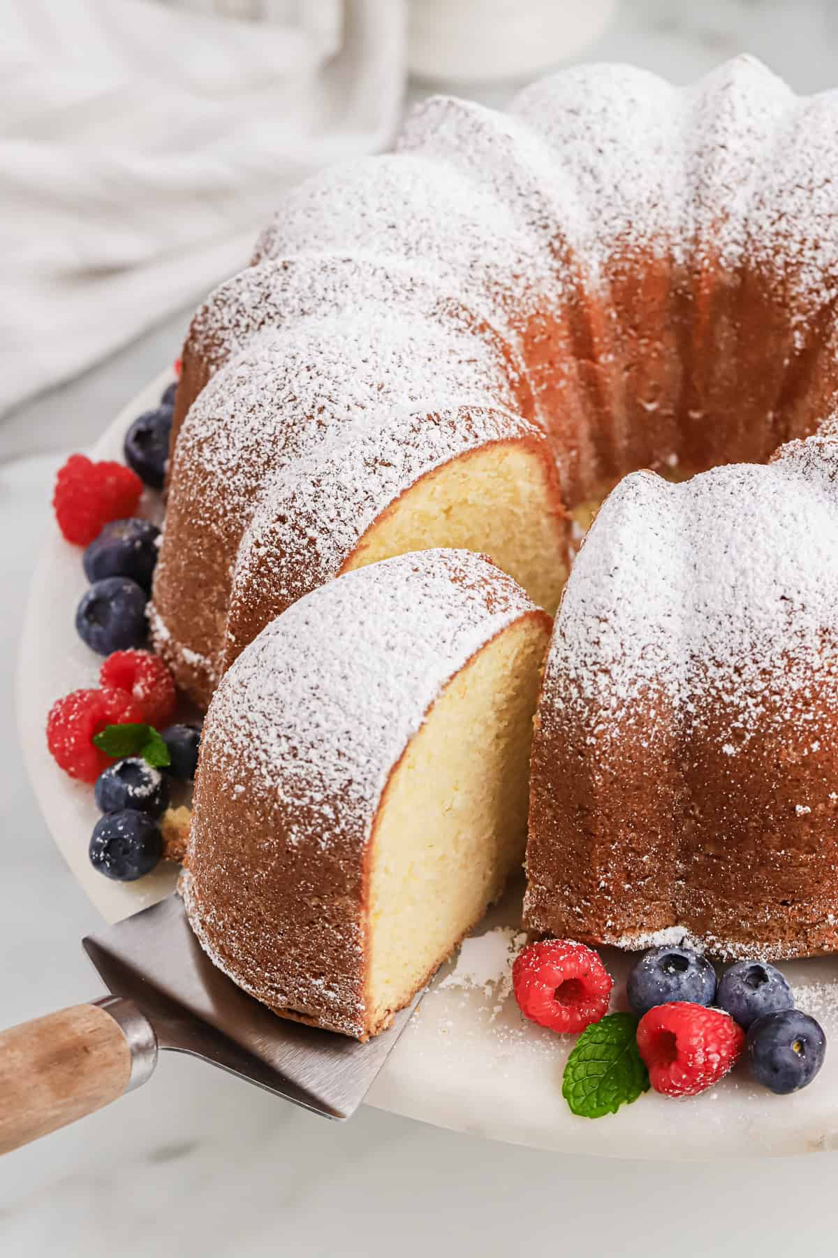 Pound cake with cream cheese being cut open with a slice being removed