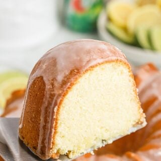 Slice of 7up cake on a spatula up over the full cake.