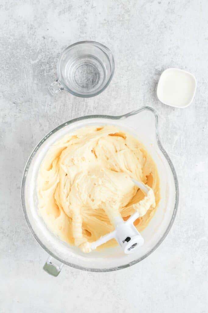 Cake batter for a 7up cake fully mixed in a stand mixer bowl with paddle attachment on white background