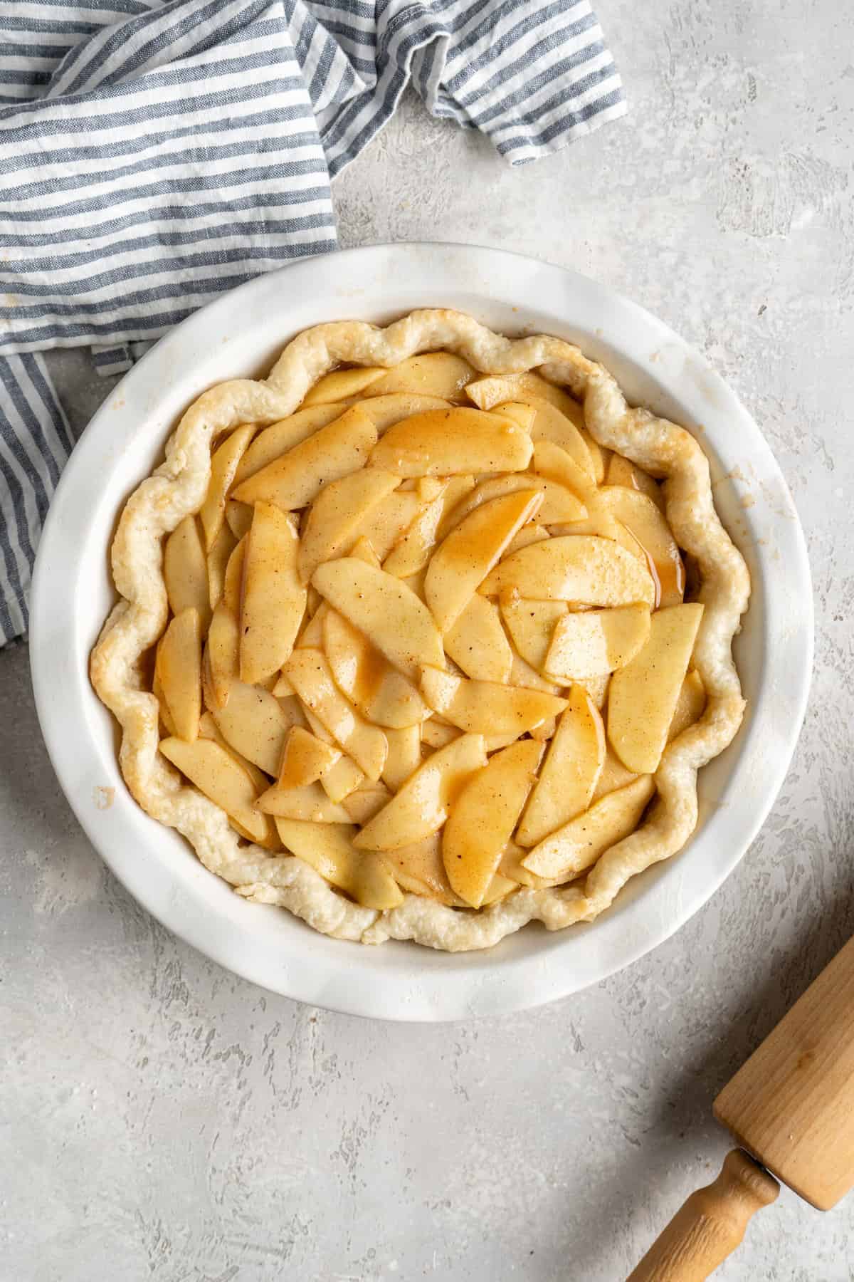 Sliced apples inside of a crimped pie dough