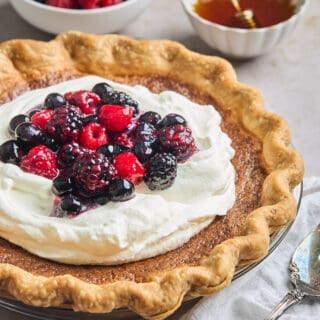 Huckleberry cream pie topped with fresh whipped cream and berries.