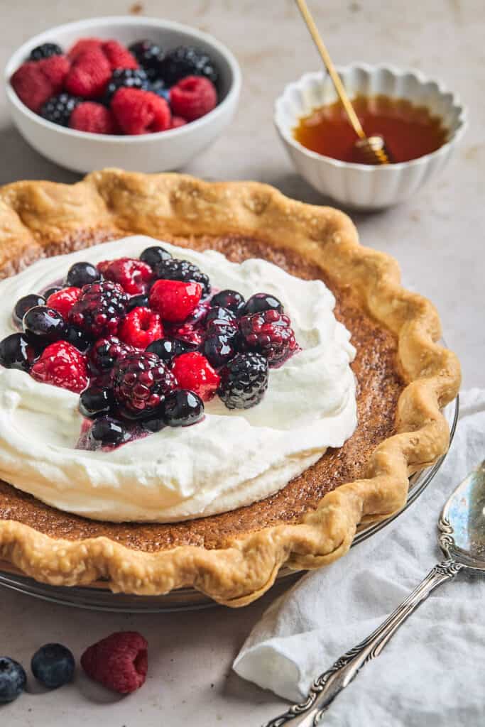 Huckleberry cream pie topped with fresh whipped cream and berries.