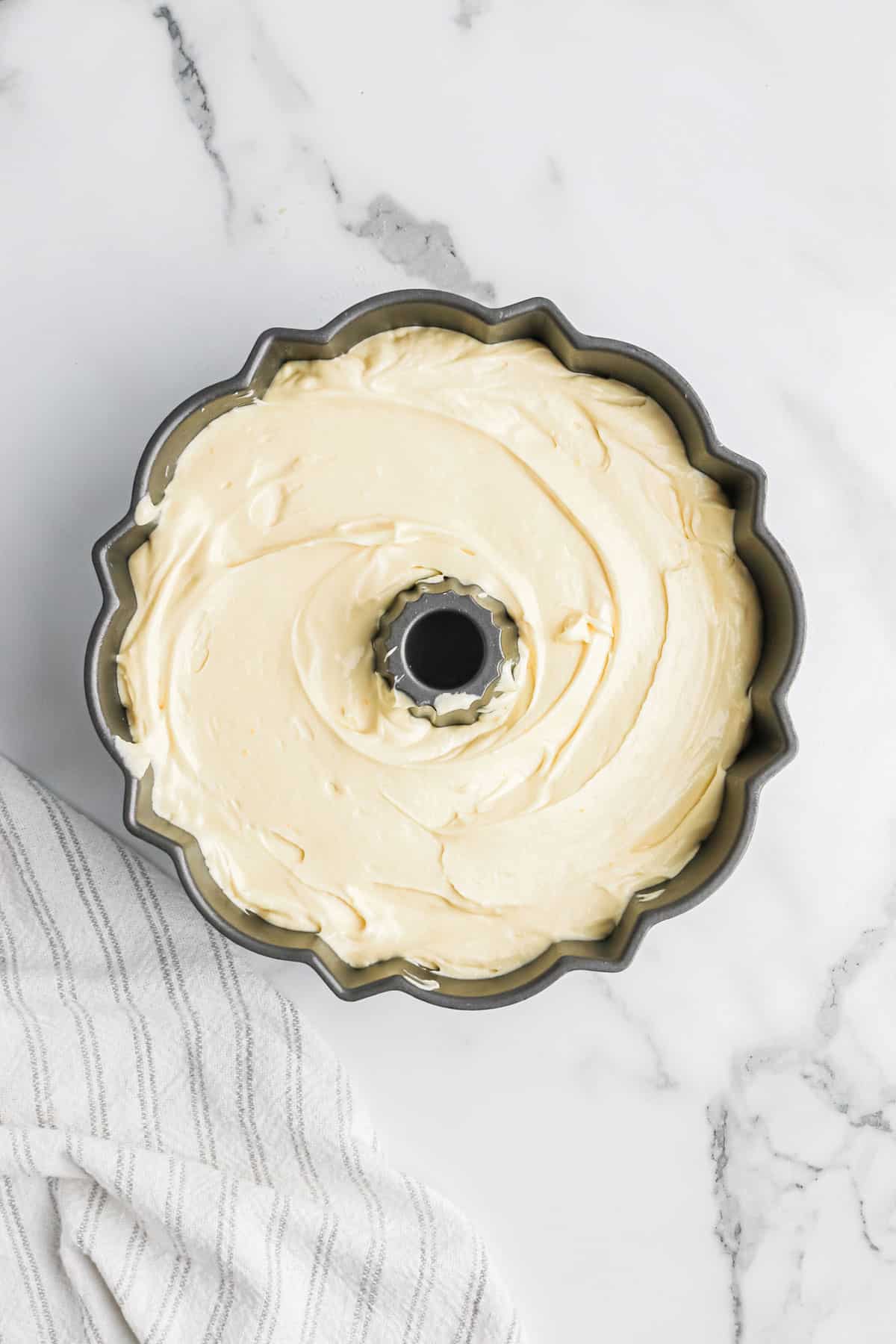 Cream cheese pound cake batter poured into a bundt pan.