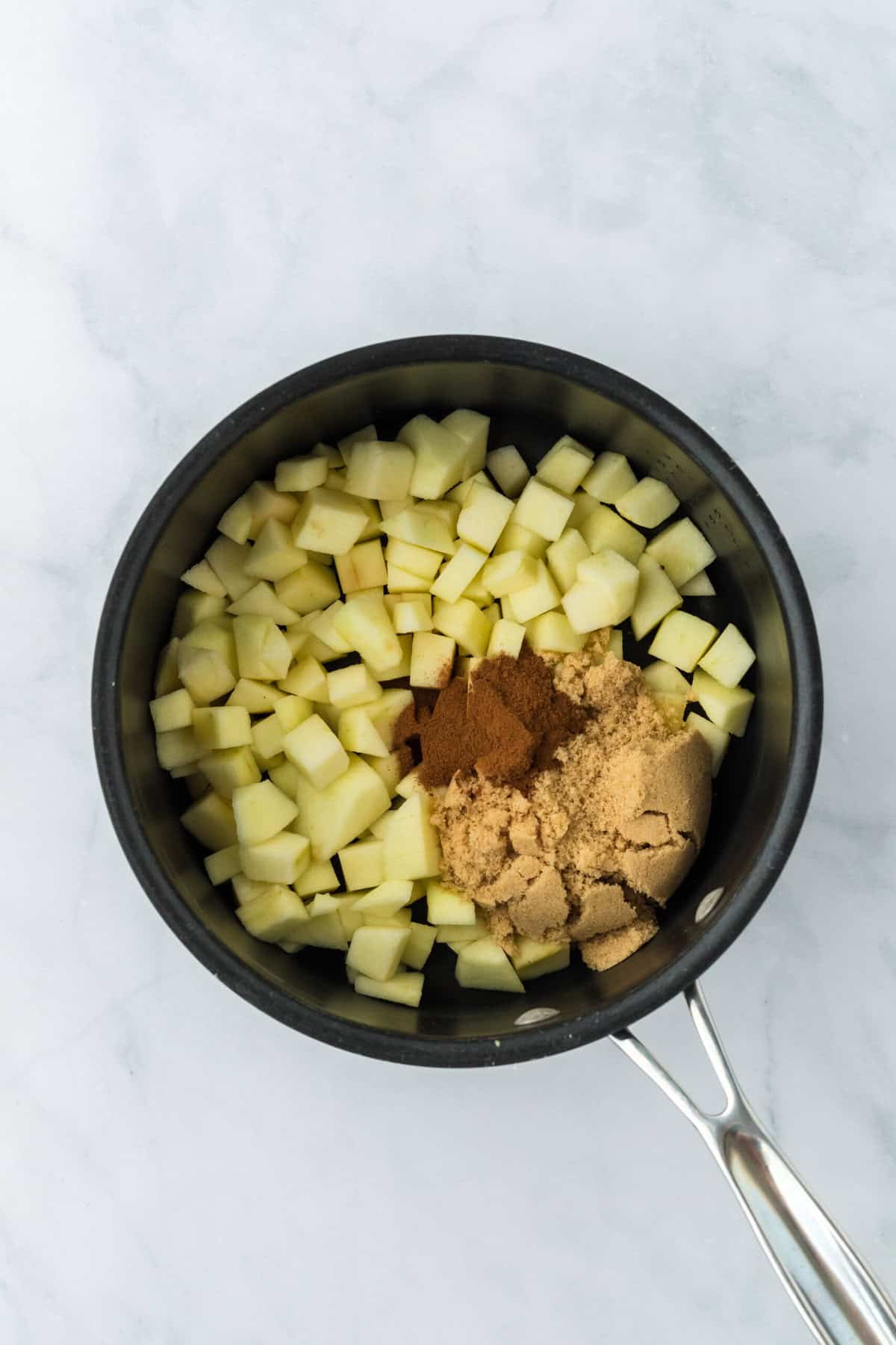 Chopped apples, brown sugar, and spices in a medium pot.