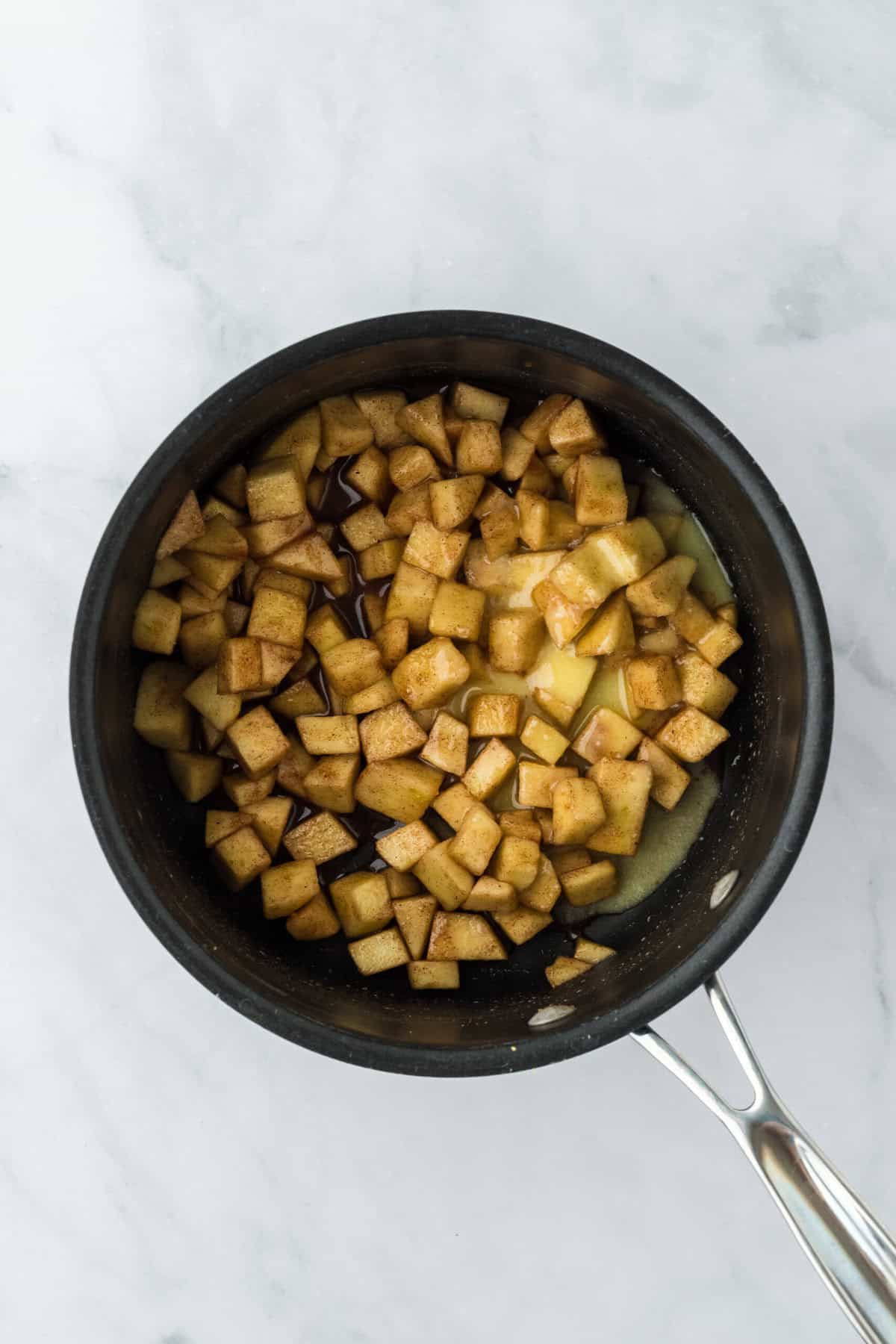 Cornstarch mixture added to chopped apples and sugar in a pot