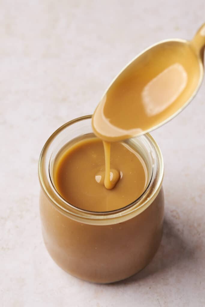 Vegan caramel sauce poured into a glass jar