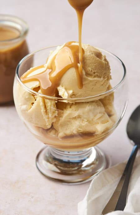 coconut caramel being drizzled overtop a bowl of ice cream