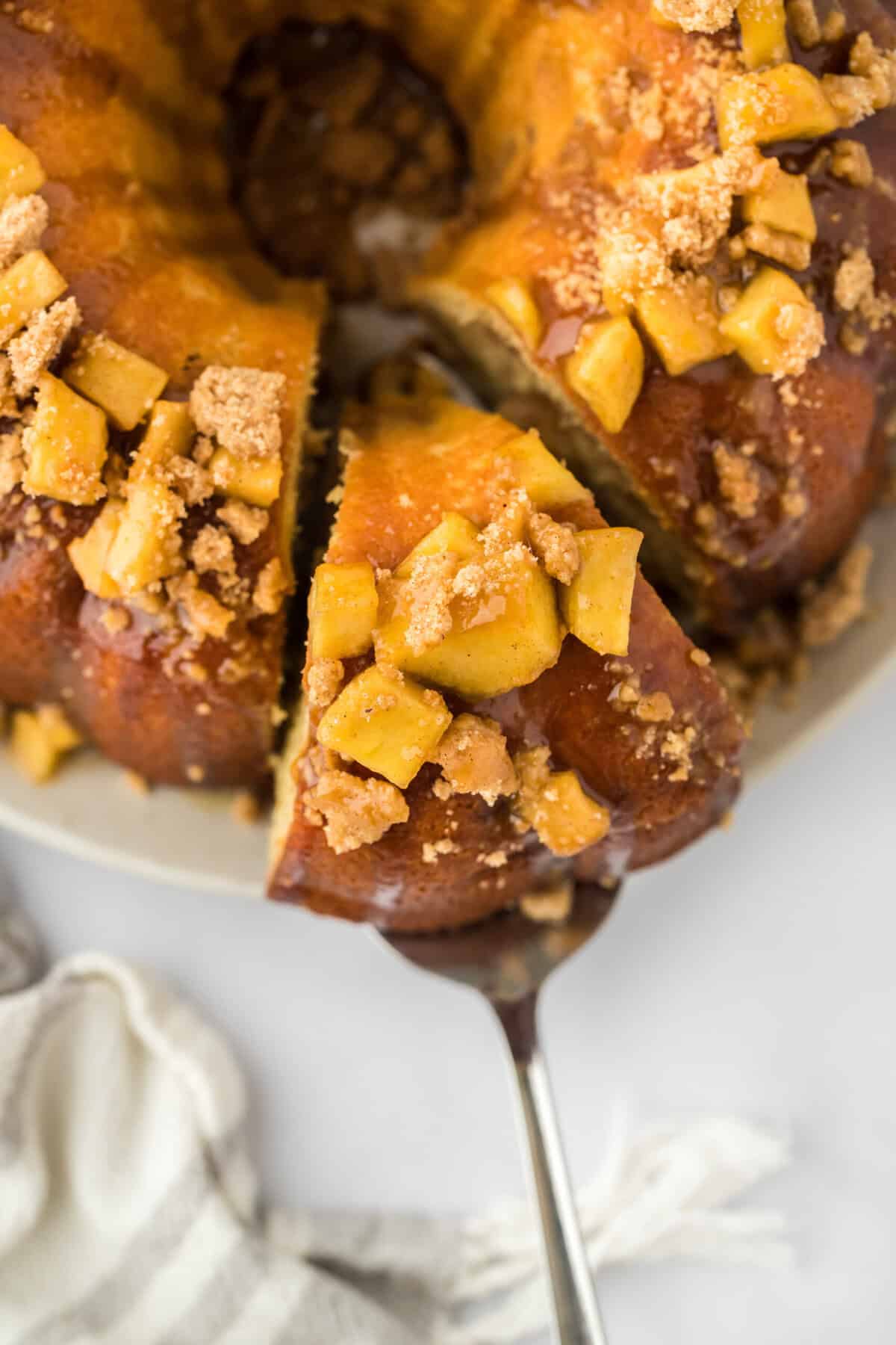 A caramel apple bundt cake shot above with a slice being removed