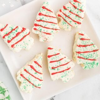Overhead view of 6 little debbie christmas tree cakes on a white platter