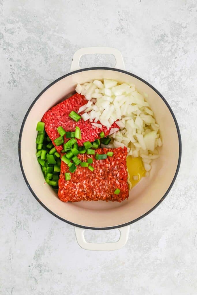 Ingredients to make beef spaghetti sauce in a pot.