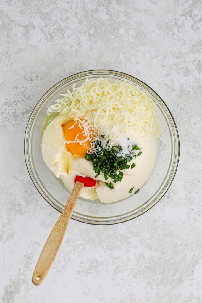 Ingredients to make the creamy filling for spaghetti casserole in a bowl.