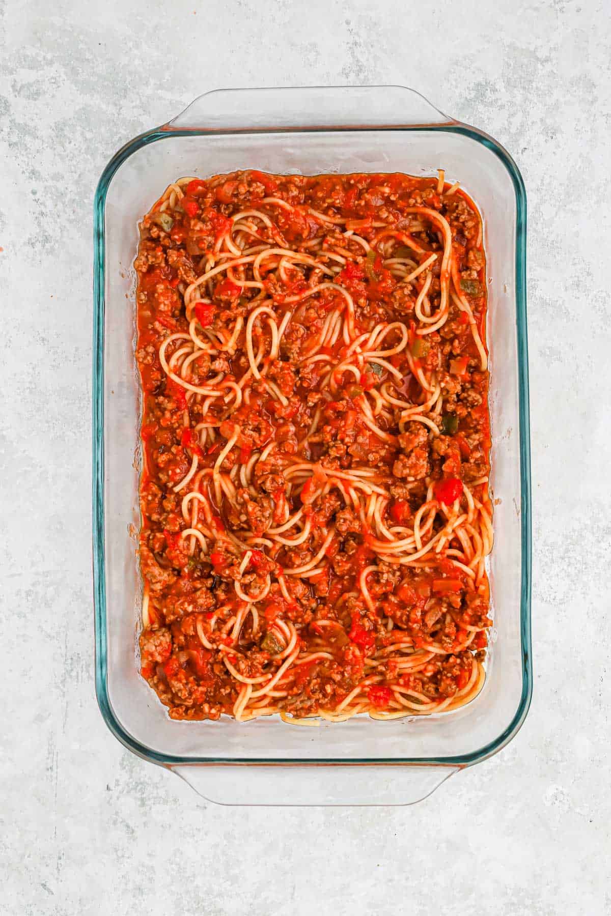 Spaghetti and meat sauce mixed together in a casserole dish.
