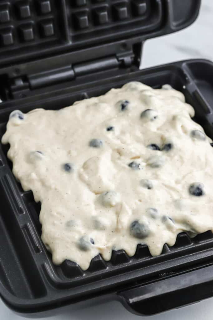 Blueberry waffle batter poured into a waffle iron