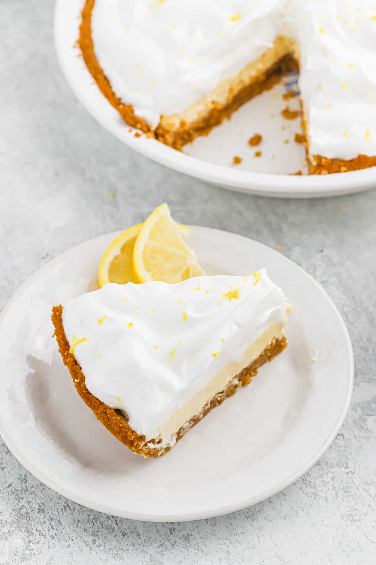 A slice of lemon meringue icebox pie on a white plate.