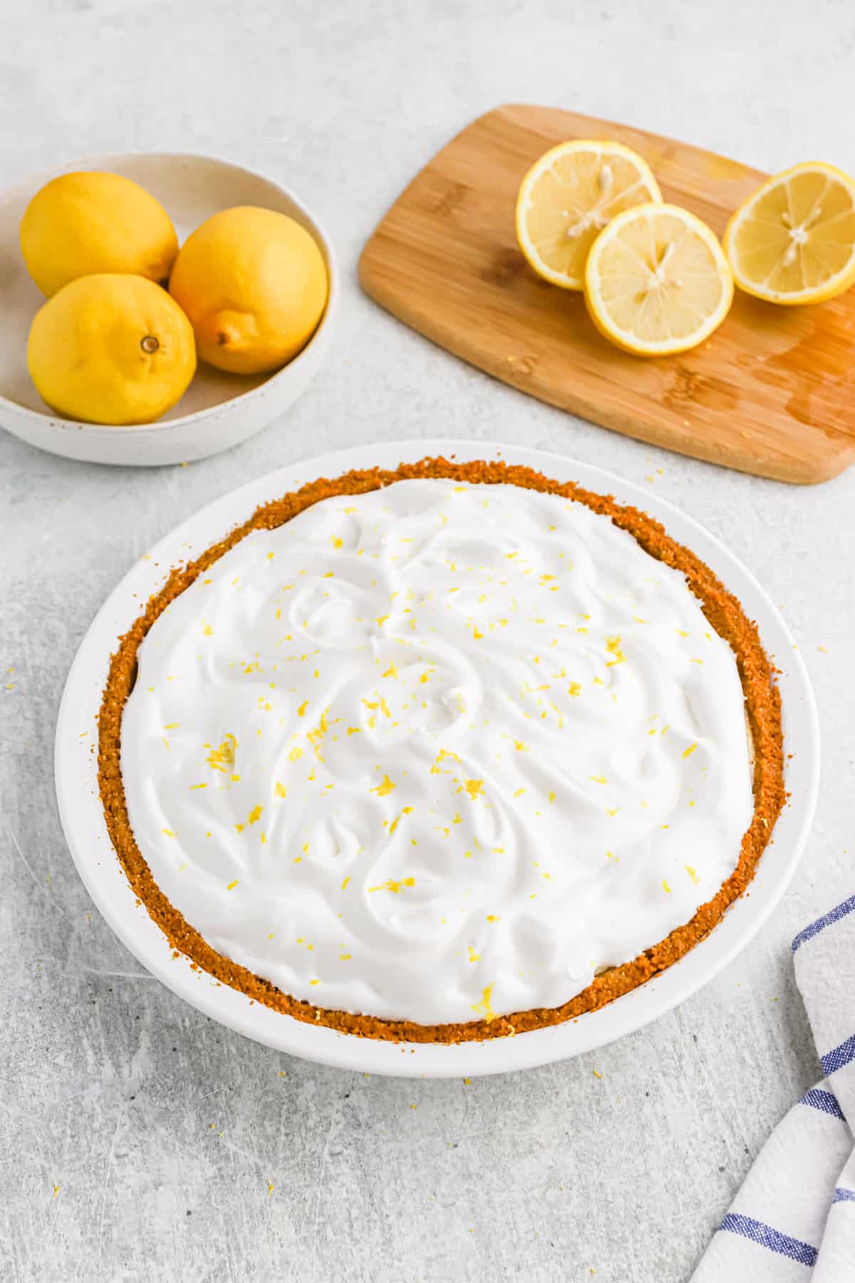 A freshly made lemon icebox pie with meringue in a white pie plate.