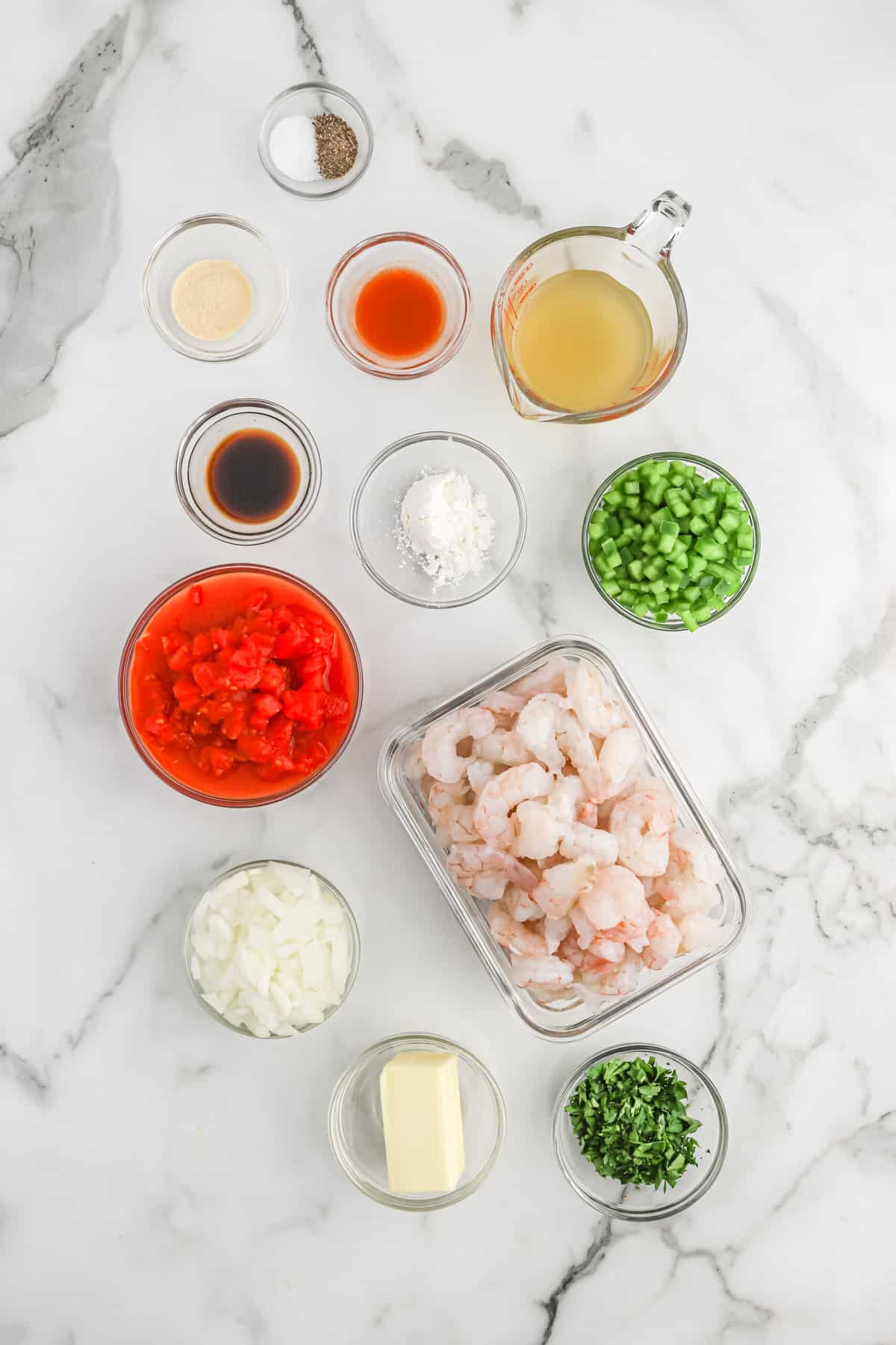 Ingredients to make shrimp creole in clear bowls