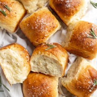 White cheddar rosemary rolls on a white towel.