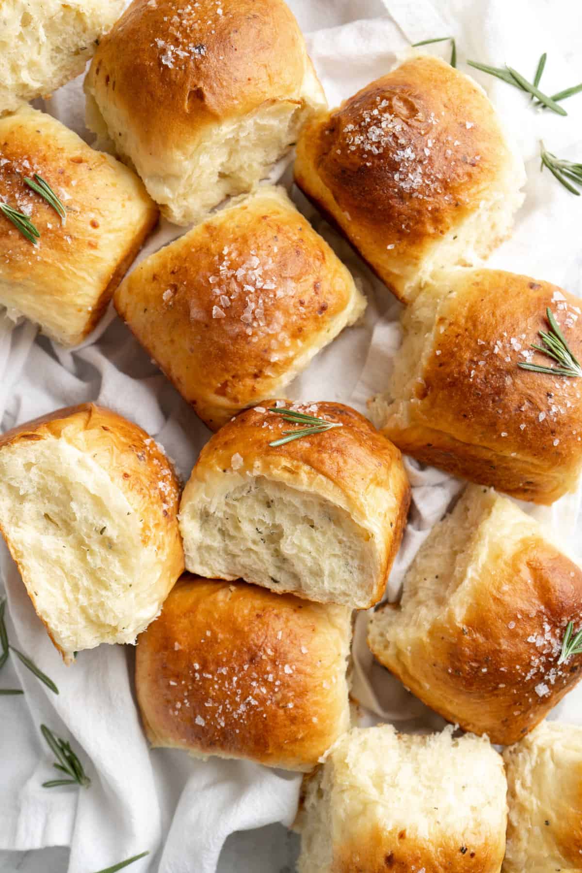 White cheddar rosemary rolls on a white towel.