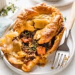 steak and ale pot pie on a white plate with a fork