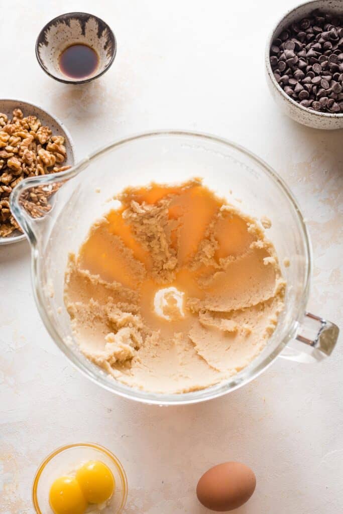 butter and sugar being creamed in a stand mixer bowl