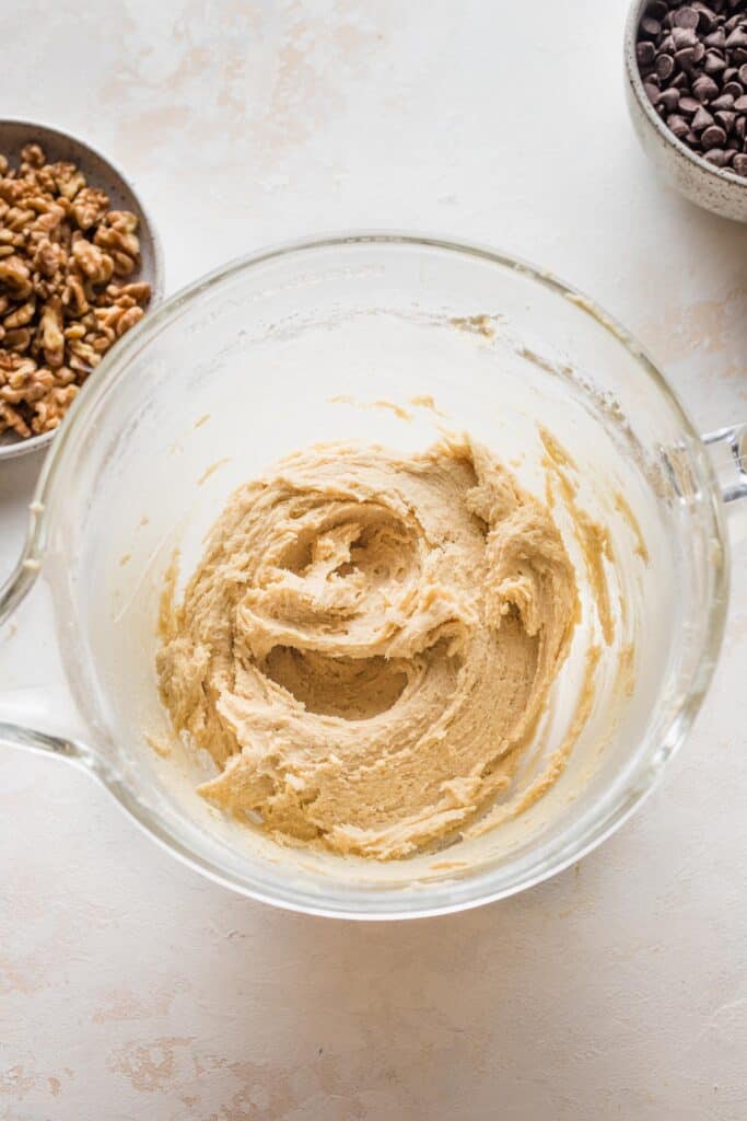 cookie dough coming together in a glass bowl