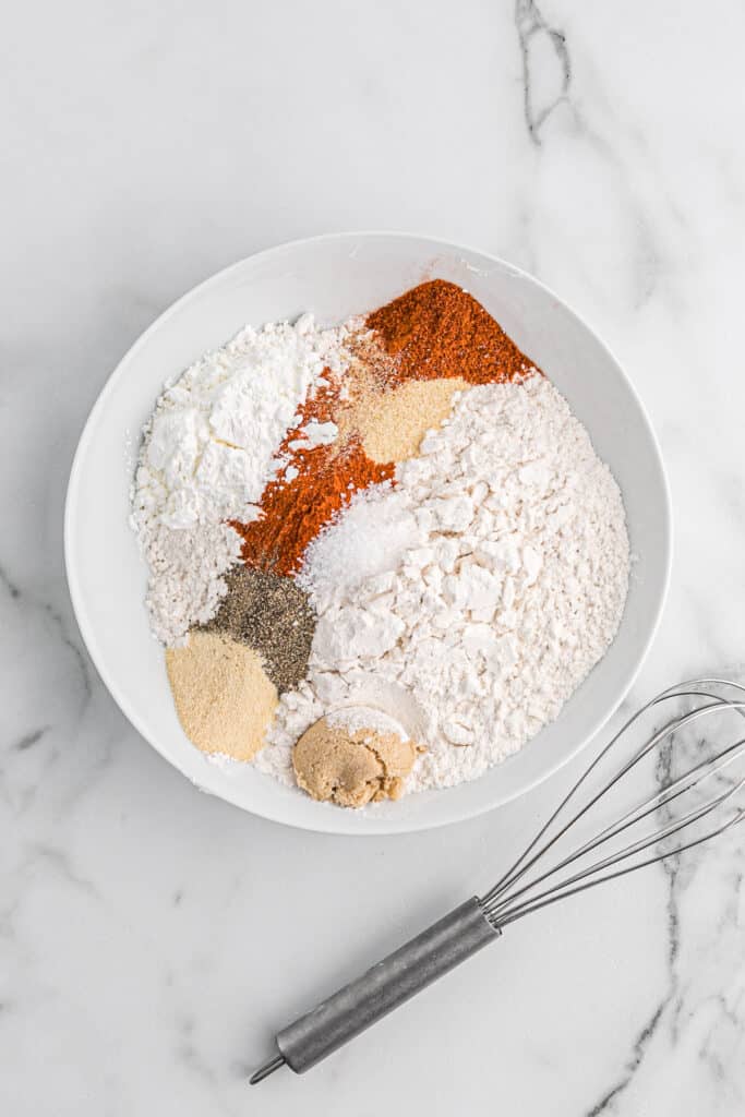 Flour and seasonings in a shallow white bowl.